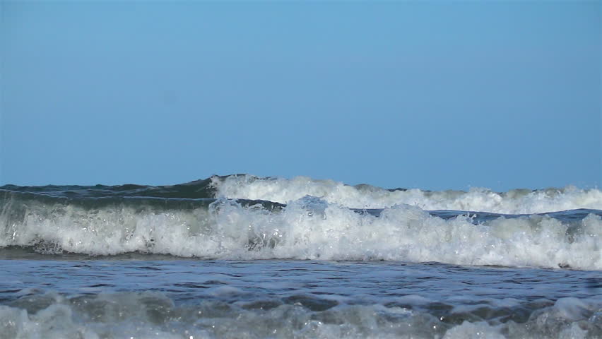 Slow Motion Shot Of Beautiful natural scene of tropical summer sand beach with blue sea and cloudy sky, ocean waves crashing on a beach island.