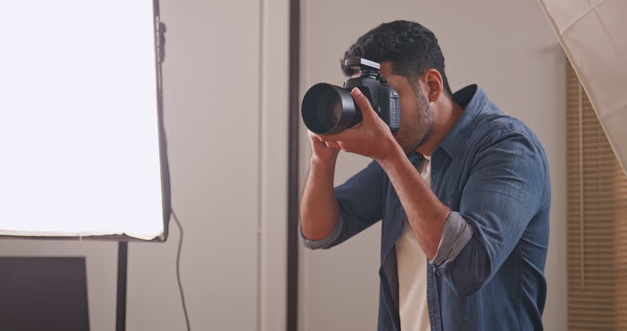 Professional male photographer working in studio. Photographer shooting model with flashlight. Royalty-Free Stock Footage #1106439741