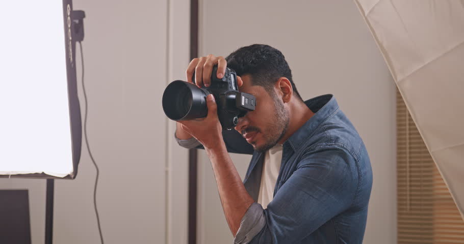 Professional male photographer working in studio. Photographer shooting model with flashlight. Royalty-Free Stock Footage #1106439741