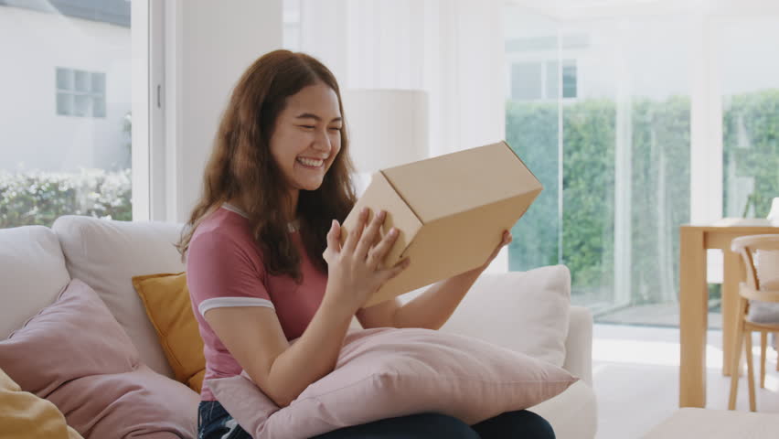 Asia people young woman smile love hug parcel box goods carton packaging happy joy awe face at home. Omni channel enjoy buy gift order postal at retail online shop store fast courier sending service.