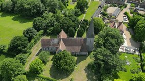 A downward aerial tilt of St John the Evangelist church, tilting down to reveal the village of Ickham in the background.