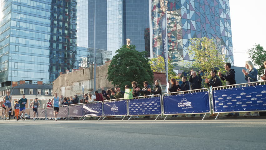 Slow Motion of a Diverse Group of People Running a Marathon in a City During the Day. Family and Friends Supporting and Cheering Male and Female Runners Competing to Reach the Finish Line