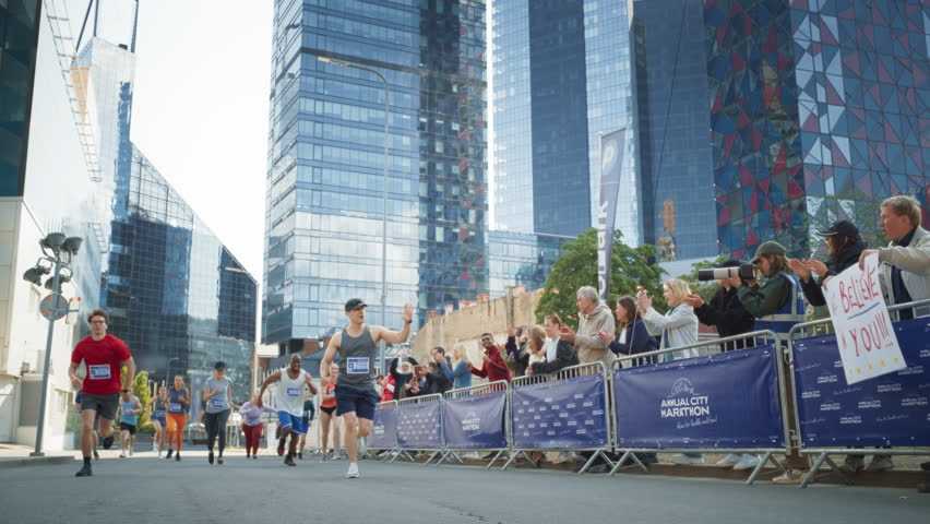 Slow Motion Portrait of a Smiling Group of People Participating in a City Marathon. Wide Shot of Diverse Race Runners Reaching the Finish Line, Celebrating Their Victory and Achieving their Goal Royalty-Free Stock Footage #1106455919
