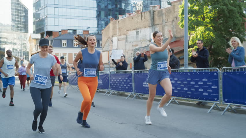Women Supporting Women: Slow Motion Portrait of Happy Female Runners Participating in a Marathon. Group of Friends Celebrating Together and Congratulating Each Other on Crossing the Finish Line Royalty-Free Stock Footage #1106455963