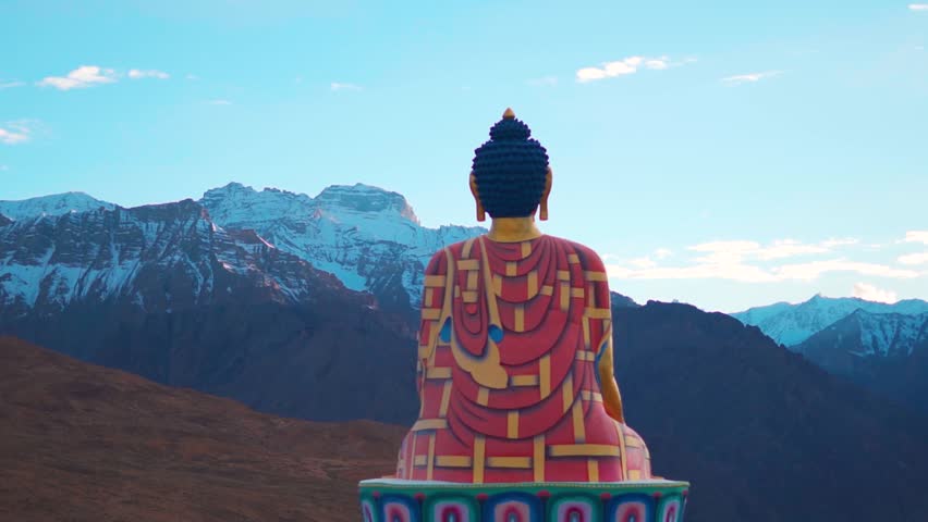 Rear view shot of Langza Buddha statue in front of the Snow covered Himalayan mountains at Langza village in Spiti Valley, Himachal Pradesh, India. Statue of Buddha facing the snowy Himalayas in India Royalty-Free Stock Footage #1106457521