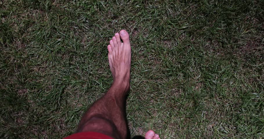 Man with bare feet walks on grass with lantern lighting fpv Royalty-Free Stock Footage #1106459861