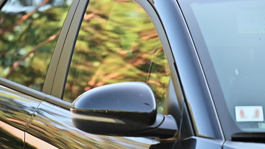 A private detective is sitting in the car, filming. The paparazzi sits in the car and photographs a famous person.