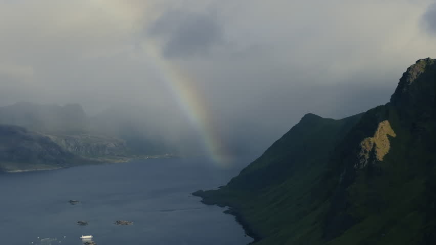 Beautifully colored rainbow over a body of water among the Scandinavian fjords. Drone view