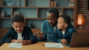 Single parent African American father man babysitter private teacher with two boys kids children help little schoolboy son child boy with school homework teaching writing task distant home education - Powered by Shutterstock - Get 15% off with code: PIKWIZARD15