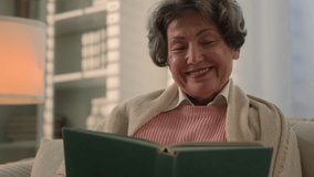 Happy inspired Caucasian old woman reading book smiling nostalgic senior mature lady elderly female retired pensioner grandmother read at home couch watching photos in album memory remember nostalgia - Powered by Shutterstock - Get 15% off with code: PIKWIZARD15