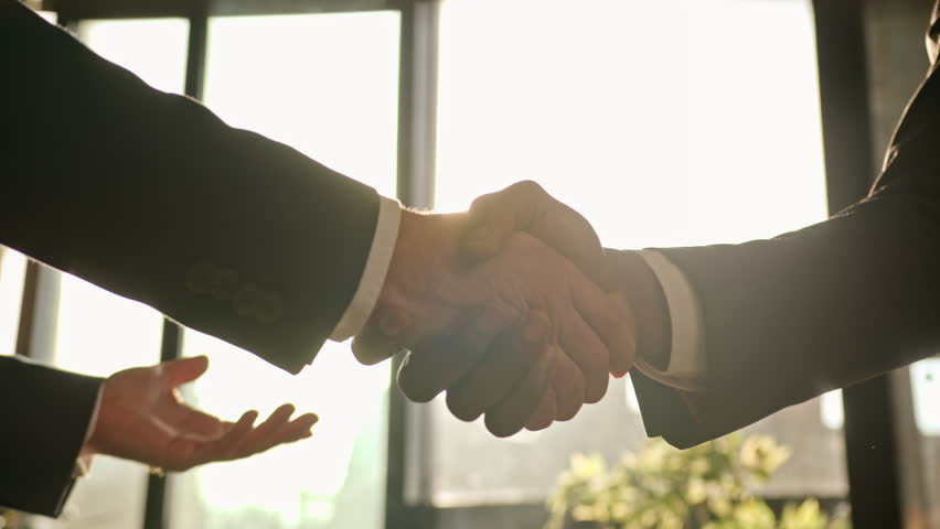Close up male hands handshaking in sunny office. Multiethnic Caucasian and African business people diverse men businessmen shaking arms successful partnership deal cooperation agreement handshake