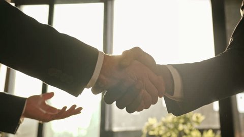 Close up male hands handshaking in sunny office. Multiethnic Caucasian and African business people diverse men businessmen shaking arms successful partnership deal cooperation agreement handshake Arkivvideo