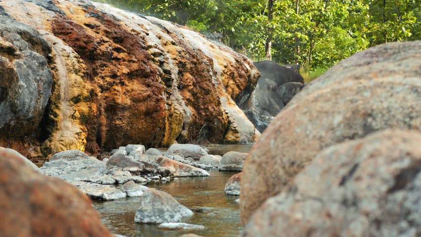 Natural Open Air Hot Springs, Steam is Coming from hot rocks and water surface. 4K Slowmotion travel destination concept footage. Norhern Thailand.