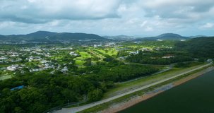 Aerial Drone video hyperlapse of golf course with road in kathu city Phuket thailand,Amazing timelapse 4K Hyperlapse drone view Transportation concept