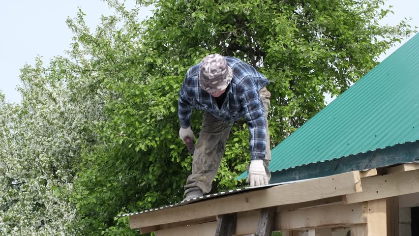 elderly man in plaid shirt as he fearlessly builds his own home from ground up. fearlessly standing on roof, it symbolizes pursuit of dreams and triumph of self-reliance. Self-Built Home Royalty-Free Stock Footage #1106479821