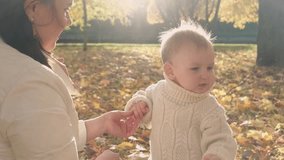 Mother with her little son walks in the autumn park. Horizontal video