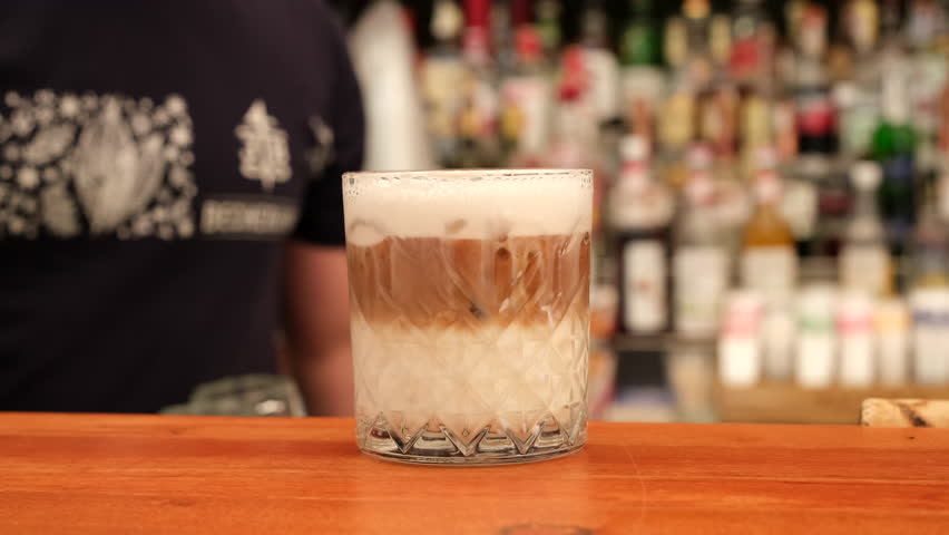 The barman's made a cocktail. Bartender prepares a cocktail, putting cocktail tube in glass Royalty-Free Stock Footage #1106482489
