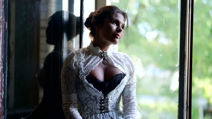 romantic mood of graceful woman in vintage gown with corset in old village house, lady with book