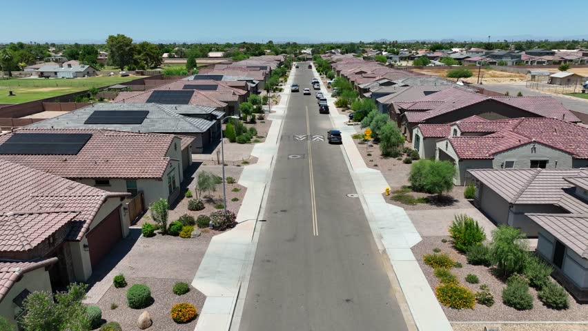 New, modern housing development in southwest USA. Aerial shot over neighborhood street. Houses and homes with solar panels and stucco architecture. Royalty-Free Stock Footage #1106484927