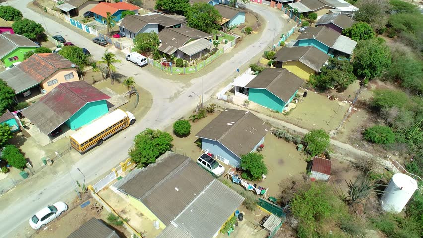 4k tilt up backwards reveal of Curacao houses with refinery in background