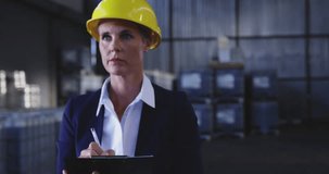 Animation of data processing on screens over biracial woman working in warehouse. Global shipping, networks, computing and data processing concept digitally generated video.