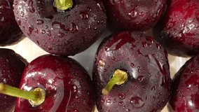 A macro video captures the intricate details of a group of dark cherries, revealing their beauty up close. The video begins with a wide shot, showcasing the arrangement of the cherries. Fruit concept
