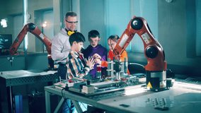 Kids and teacher observing robotic devices. Modern education concept. - Powered by Shutterstock - Get 15% off with code: PIKWIZARD15