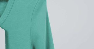 Video of green t shirt with tag and copy space on white background. Fashion, trends and clothing concept.