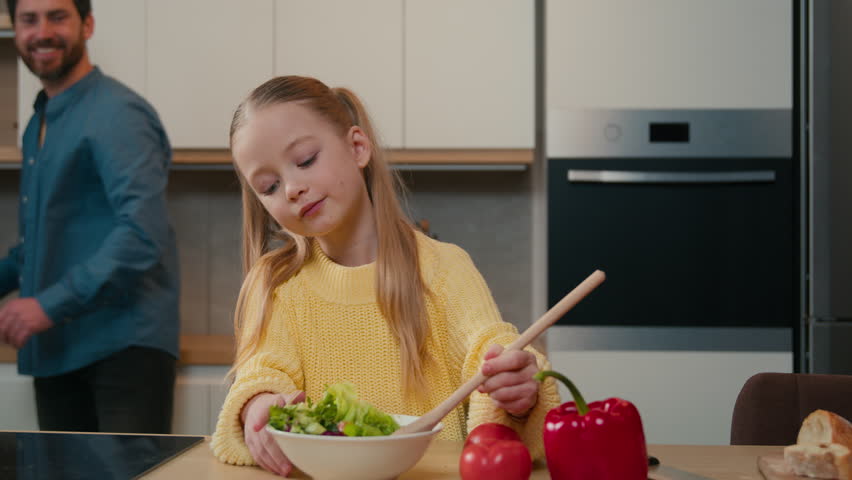 10s little Caucasian girl child kid alone cooking vegetarian fresh healthy dish breakfast dinner salad mix vegetables cook food father adult man daddy hug cuddle daughter happy family at home kitchen Royalty-Free Stock Footage #1106496789