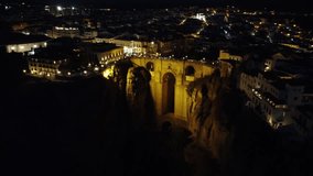 Night-time 4K drone video features Puente Nuevo Bridge in Ronda. Perfect for Spanish landmarks and nocturnal scenes projects.