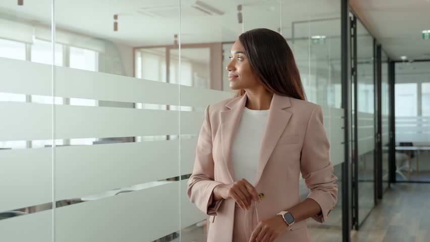 Confident smiling young professional business woman ceo corporate leader, female African American lawyer or hr manager wearing suit standing crossing arms in office, portrait. Royalty-Free Stock Footage #1106501843