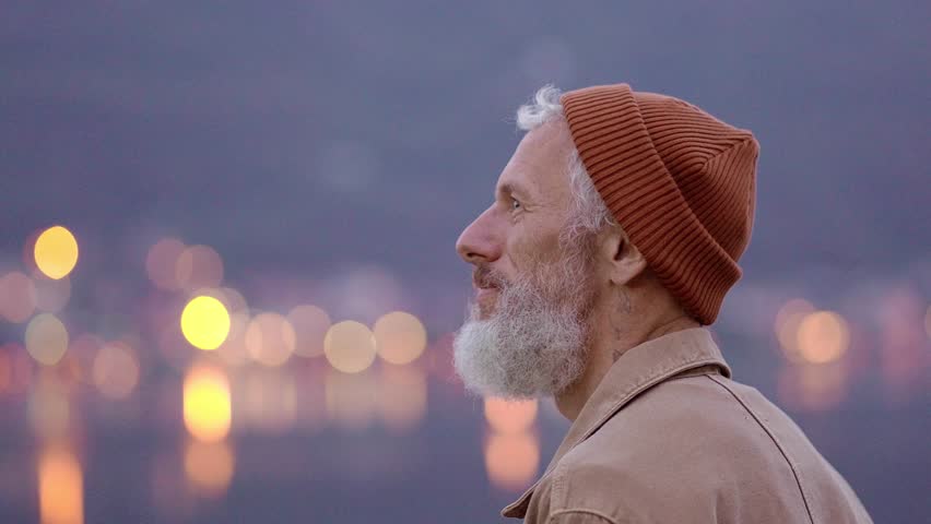 Happy older man standing in nature park enjoying natural park landscape. Smiling mature active traveler exploring camping tourism nature lake and mountains travel journey feeling freedom.