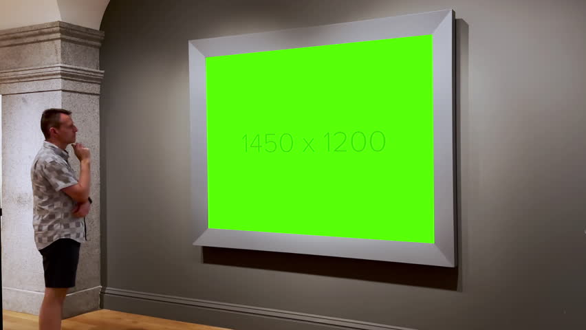 A man walks up to a large piece of artwork in a museum. Green screen for your custom art.  	