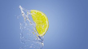 fresh lemon is hit by a splash of water in super slow motion.The close-up shot captures the water droplets flying through the air, while the lemon is sliced and dropped into the splash.blue background - Powered by Shutterstock - Get 15% off with code: PIKWIZARD15