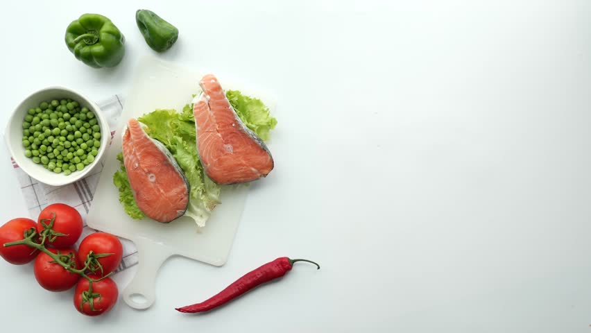 Raw, fresh salmon steak and vegetables on white 