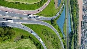 Aerial view of road junction with moving cars. Road interchange or highway intersection. Aerial view, top down view of traffic. Roundabout traffic of cars and trucks on the circle ring road. Vertical.