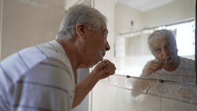 Casual Domestic Scene of Elderly Man Brushing Teeth as Part of Morning Routine. older person dental hygiene and washing face, starting the day ritual - Powered by Shutterstock - Get 15% off with code: PIKWIZARD15