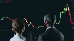 Colleagues traders are working with multiple computer screens full of charts and data analysis and stock broker trading online. Back view. Concept of bitcoin and stock market trading. - Powered by Shutterstock - Get 15% off with code: PIKWIZARD15