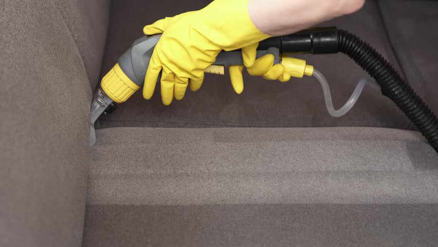 Dry cleaner's man employee removing dirt from furniture in flat, closeup, vacuum clean sofa with professional equipment. cleaning sofa with washing suction cleaner closeup. Royalty-Free Stock Footage #1106532999