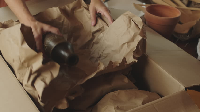 Removal, movement concept. Woman wrapping stuffs in packaging material. Royalty-Free Stock Footage #1106534889