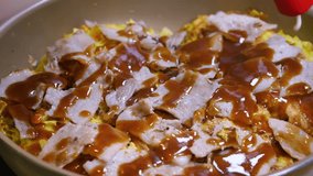 Japanese Okonomiyaki. A video of topping okonomiyaki with mayonnaise and katsuobushi.