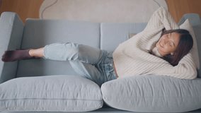 Top view - Happy young asian woman falling on huge comfortable couch and relaxation in living room, Enjoying carefree weekend. - Powered by Shutterstock - Get 15% off with code: PIKWIZARD15
