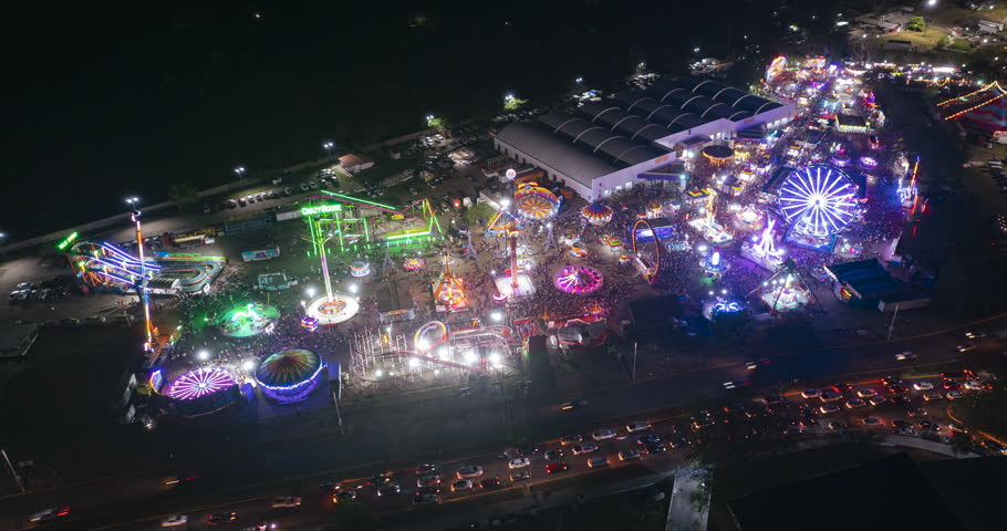 Arerial view over a large fair in Villahermosa city Tabasco at night, drone orbital hyper lapse, México, ferris wheel. Side amusement parks. Tabasco Fair