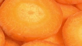 Fresh sliced carrots rotate as a background. Carrot juice or lemonade for bars, restaurants, cafes or as a backdrop for a cooking video