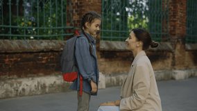 Happy mother escorts child to school. Kid happy dream concept. Girl rushes to lesson back to school. Positive girl talk to mom and hug her. Morning before the school - Powered by Shutterstock - Get 15% off with code: PIKWIZARD15