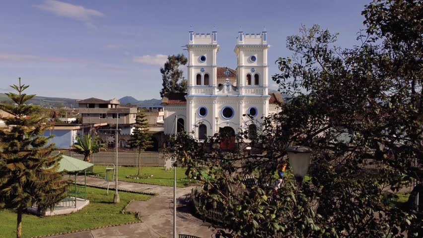 close-up drone shot passing near some tree branches, in 4k of the Tucuso church in the city of Machachi, Pichincha, Ecuador, on a sunny day.
