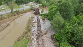 Aerial Drone View: Damaged and Eroded Train Tracks Adjacent to River in Flood-Stricken Vermont