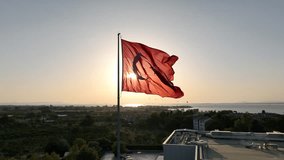Aerial shot of waving turkish flag on a sunny day with the sun shining behind it