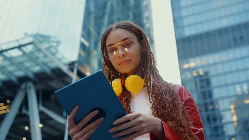 Young alternative multiethnic woman spending time in a modern part of the city. Female programmer going to work in the office