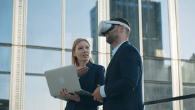 Two business partners man in virtual reality glasses and woman with laptop in hands, future VR presentation of new development project, office building rooftop terrace overlooking city downtown - Powered by Shutterstock - Get 15% off with code: PIKWIZARD15